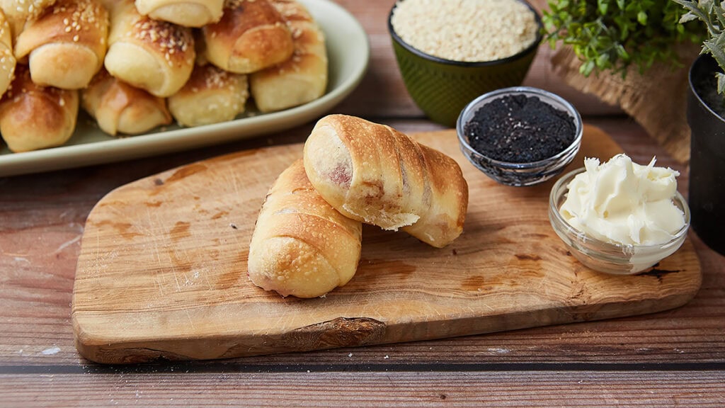 Domaće kiflice sa višnjama i belom čokoladom na drvenoj dasci.