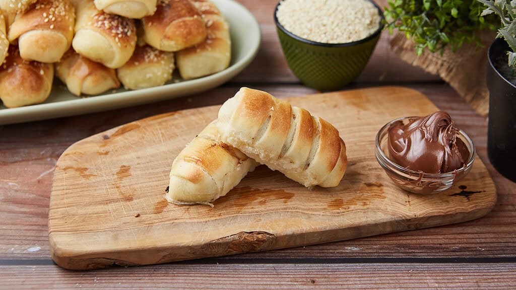 Sveže domaće kiflice bez aditiva na drvenoj dasci.