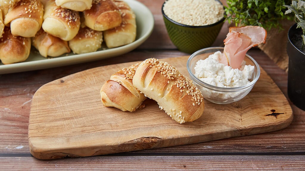 Sveže domaće kiflice bez aditiva na drvenoj dasci.